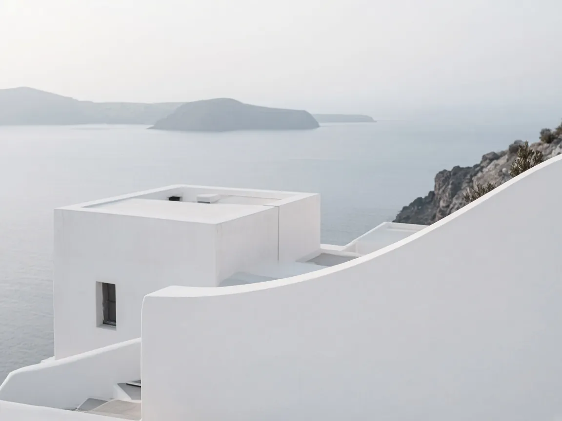 Arquitetura branca de linhas curvas sobre o mar calmo de Santorini, sob luz fria da manhã